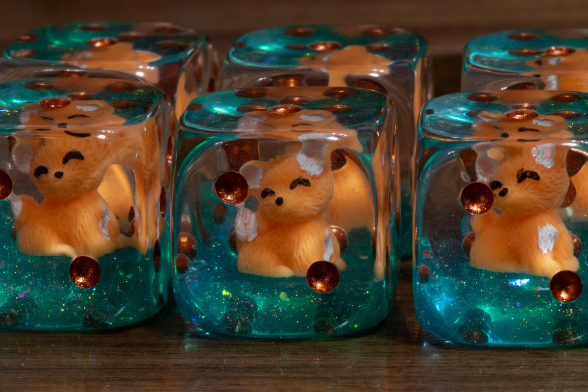 Close-up of Fox's Cunning PIP D6 dice – fox cub figurine inside with copper pips