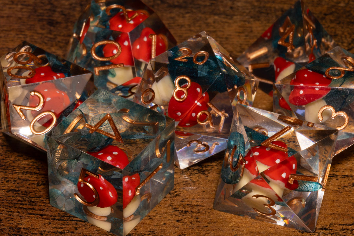 Toadstool Hollow 7-Piece Sharp Edge Dice Set – Clear with Red Mushroom & Moss Inclusions
