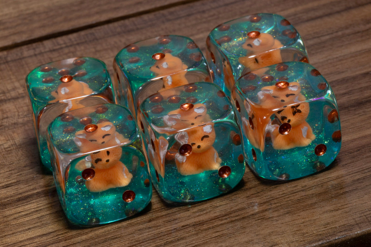 Fox's Cunning PIP D6 dice – fox cub figurines in clear resin on a teal glitter layer