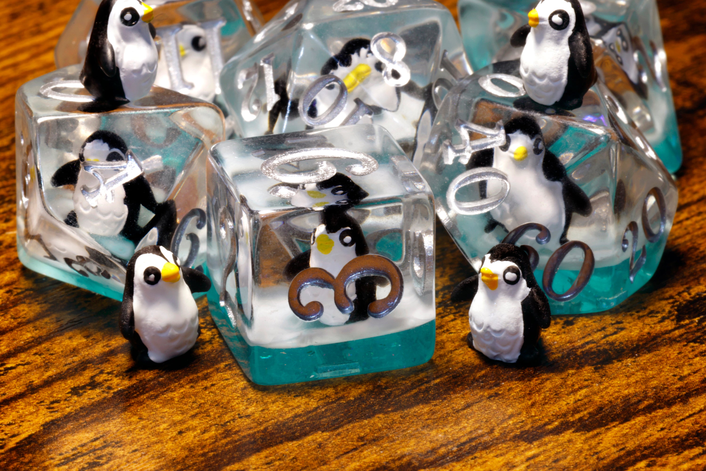 a group of penguin figurines sitting on top of ice cubes