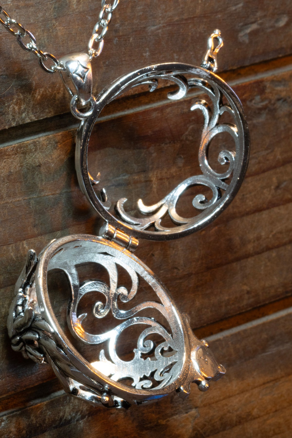 Dragon pendant in a silver finish shown open and empty, showing the hinge, the latch and the openwork inside