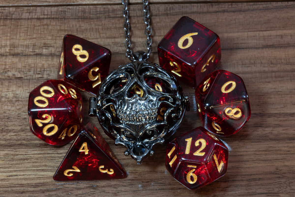 Skull pendant in a black finish with a Cherry Opal dice set on wood