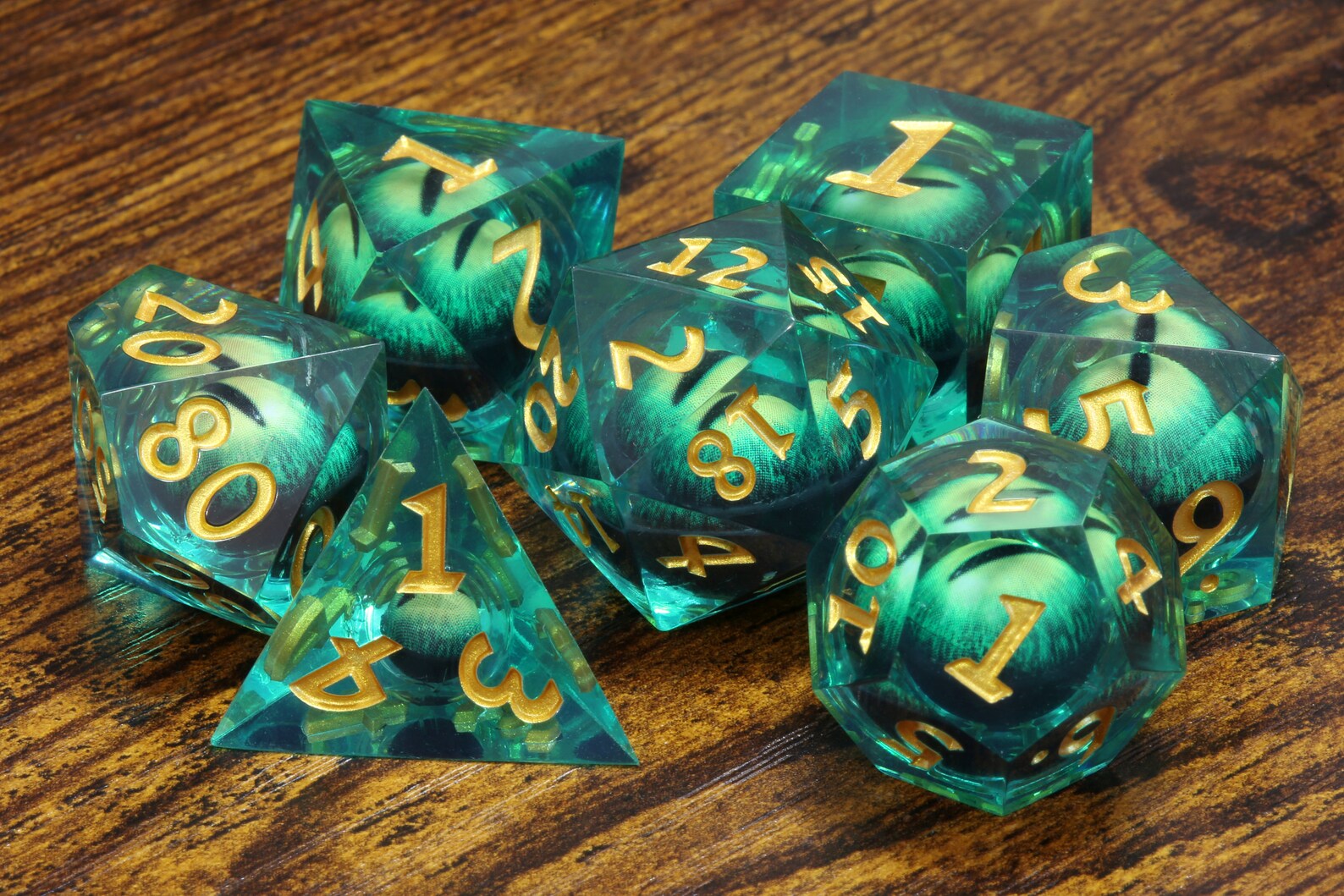Basilisk Gaze dice set - Liquid Core sharp edge dice with green moving eyes - The Wizard's Vault