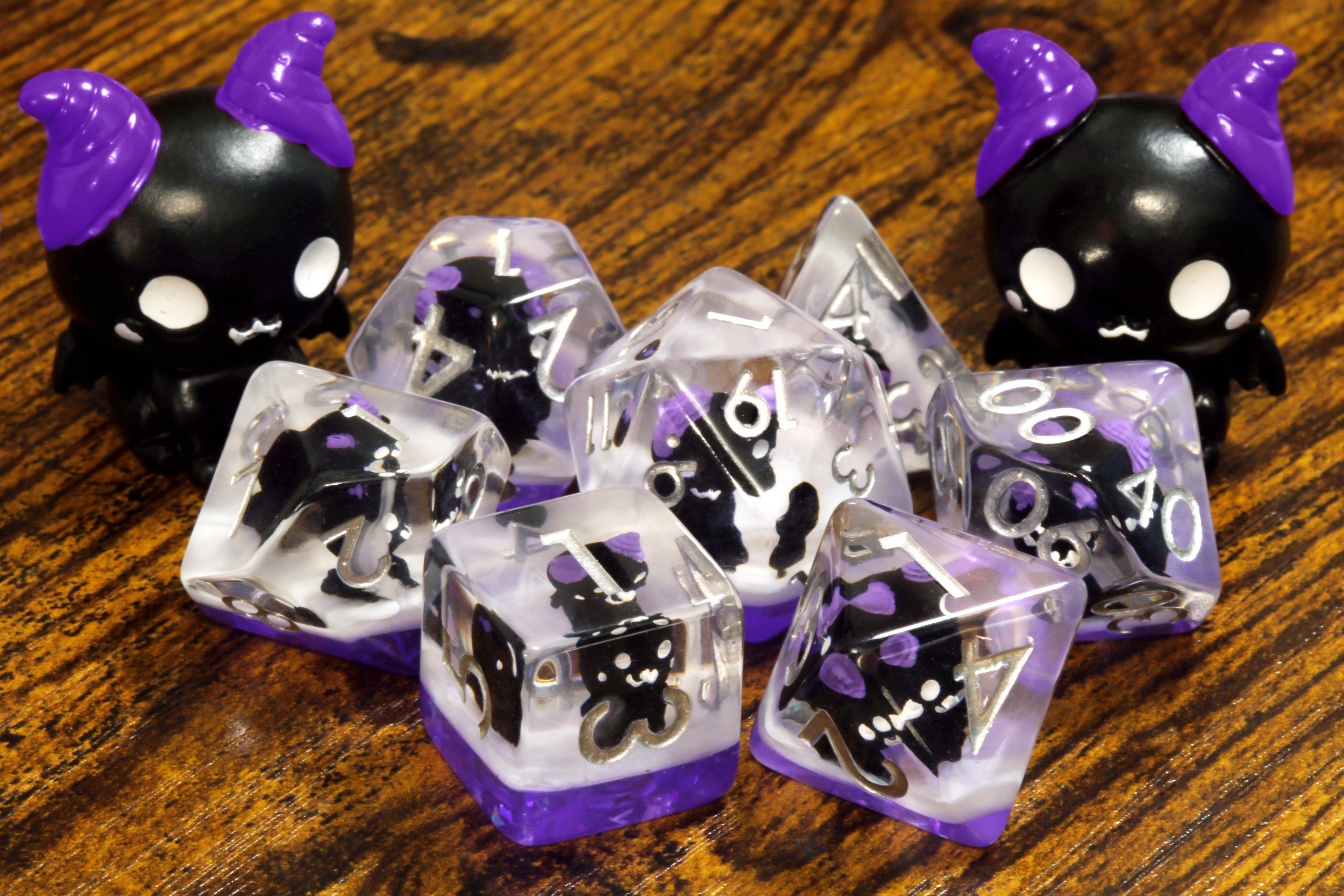 Cats of doom dice set - Dice set with winged cats on an purple layer - The Wizard's Vault
