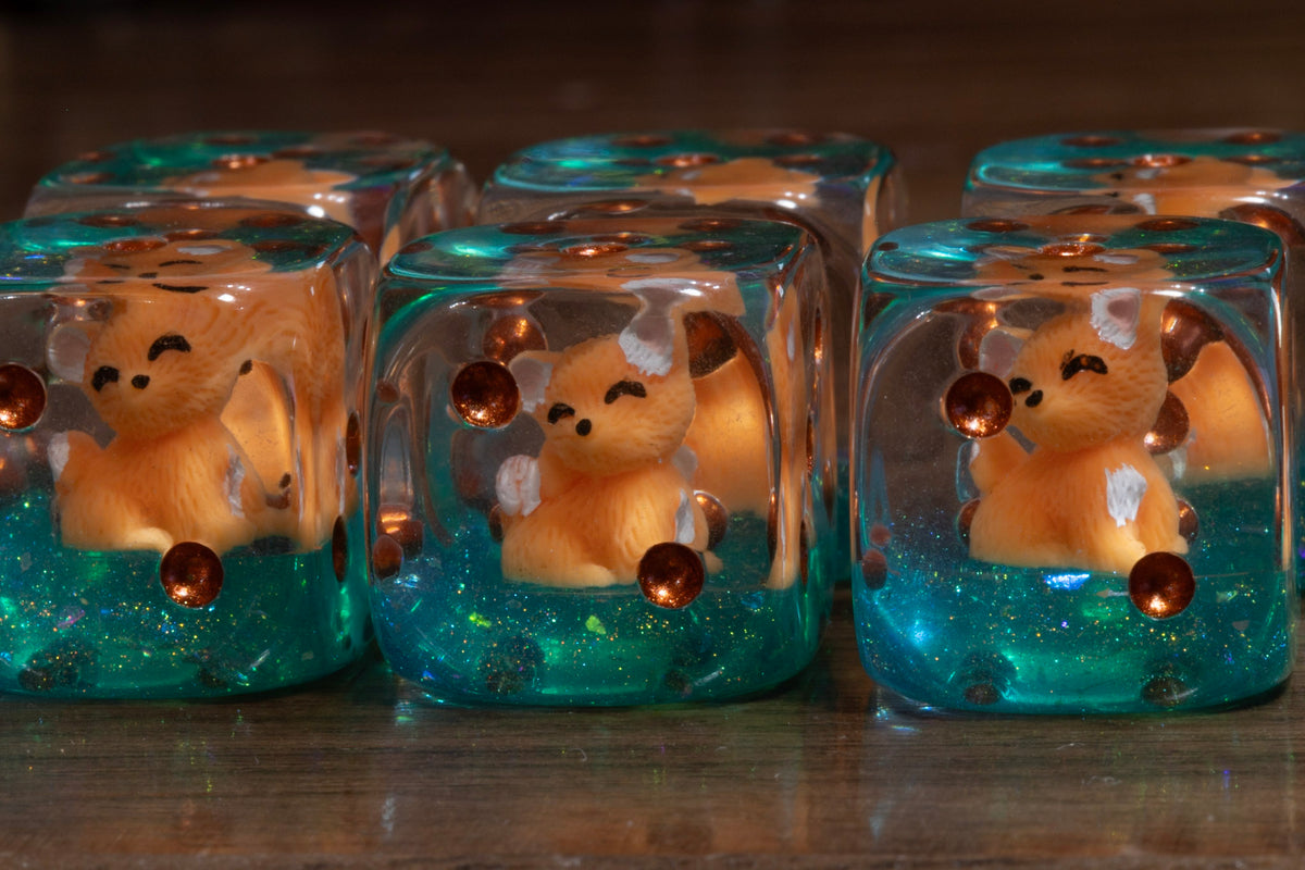 Close-up of Fox's Cunning PIP D6 dice – fox cub figurine inside with copper pips
