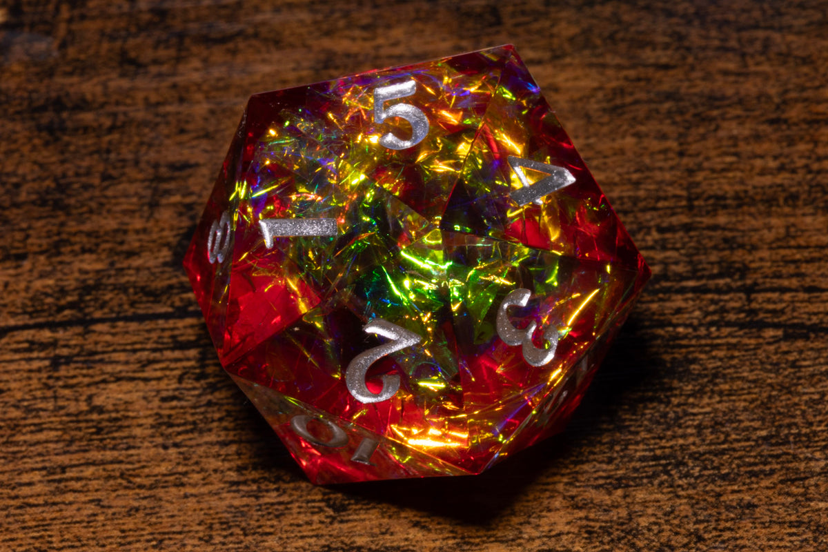 A colorful, glittery, and translucent dice with numbers on it, resting on a wooden surface.