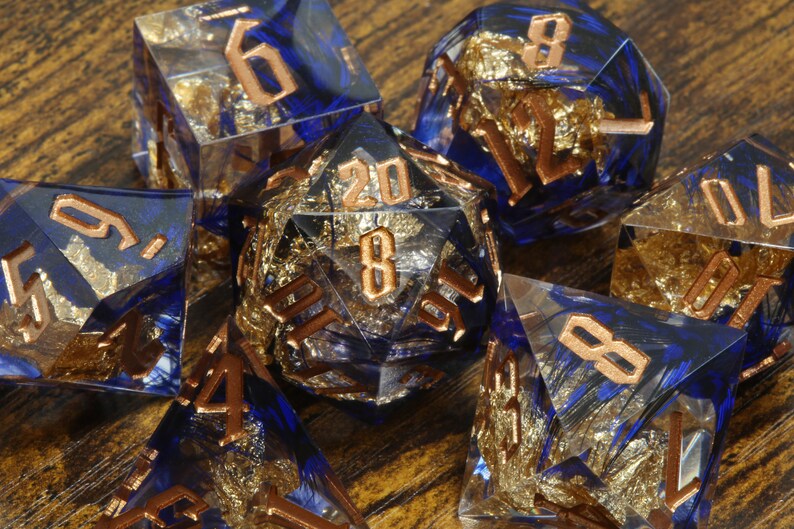 Griffin's Might dice set - Blue feather sharp edge dice set with gold flakes - The Wizard's Vault